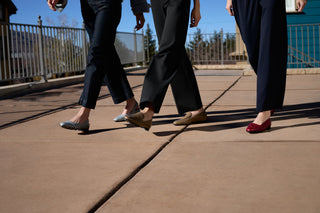 Two women walking outdoors in TFR Shoes, one in navy flats, one in red